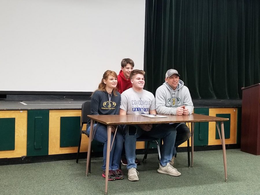 Palmquists parents sit next to him as he gets ready to sign his Letter of Intent to Concordia University Wisconsin.