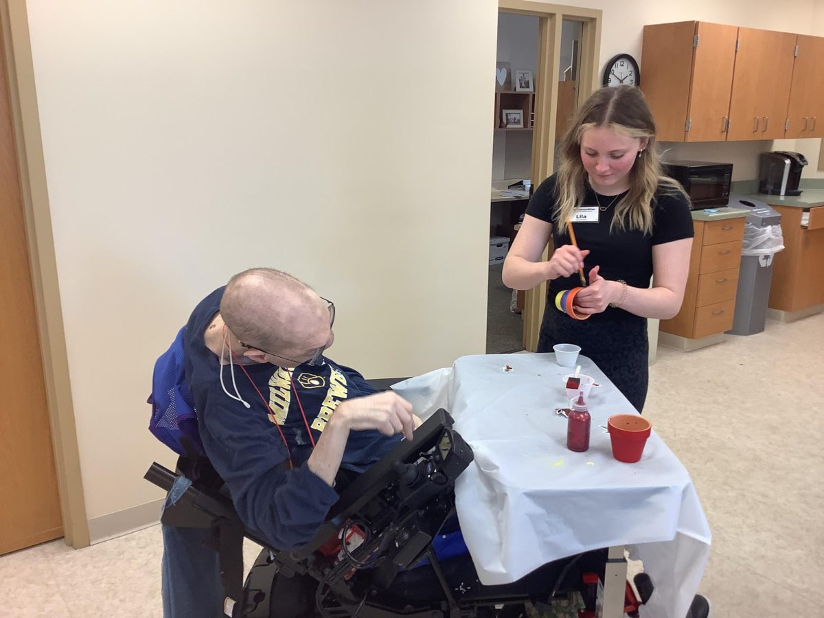 Junior Lila Murphy works with a resident at Park View Health Center. Communities students partnered with Director Missy Grundman to volunteer and gain real-world skills. 